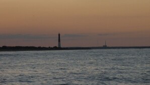 A lighthouse by the sea during sunset. - Historic District Ocean Block Lbi Duplex with free tram to the beach (Barnegat Light)