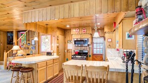 Een houten blokhut van binnen, met keuken, bar en zithoek.