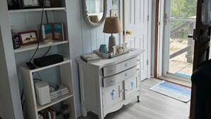 A room with a white dresser, a television mounted above it, and a door leading outside. -  Cozy Cape Cottage on Private Beach with HVAC split AC/Heating system (Sandwich)