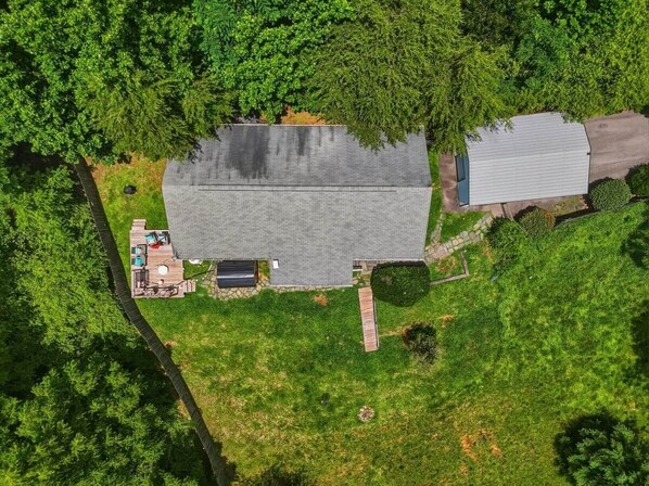 An aerial view of a house with a large garage, a fenced yard, and a small deck with outdoor furniture. - Mountain View ranch w/ sauna, 1ac fence & firepit. (Candler)