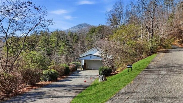 A residential driveway leading to a garage with a house number 72, surrounded by trees and a mountain in the background. - Mountain View ranch w/ sauna, 1ac fence & firepit. (Candler)