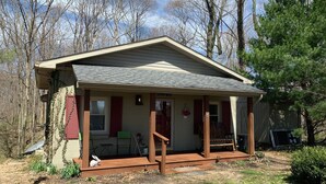 A small, single-story house with a porch, a front door, and a small window.