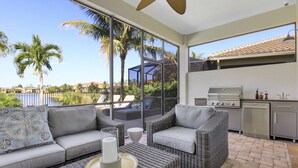 Un espacio exterior moderno con una sala, sillas y una mesa de comedor.