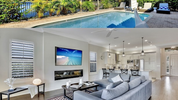 Una vivienda moderna con piscina, sala de estar con televisor grande y cocina con armarios blancos.
