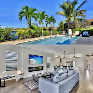 Ein modernes Haus mit Swimmingpool, einem Wohnzimmer mit großem Fernseher und einer Küche mit weißen Schränken.