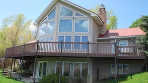 A two-story house with a balcony and a chimney.