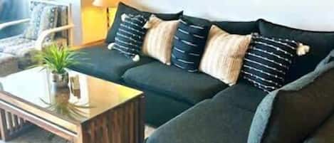 A living room with a sofa, coffee table, and artwork on the wall.