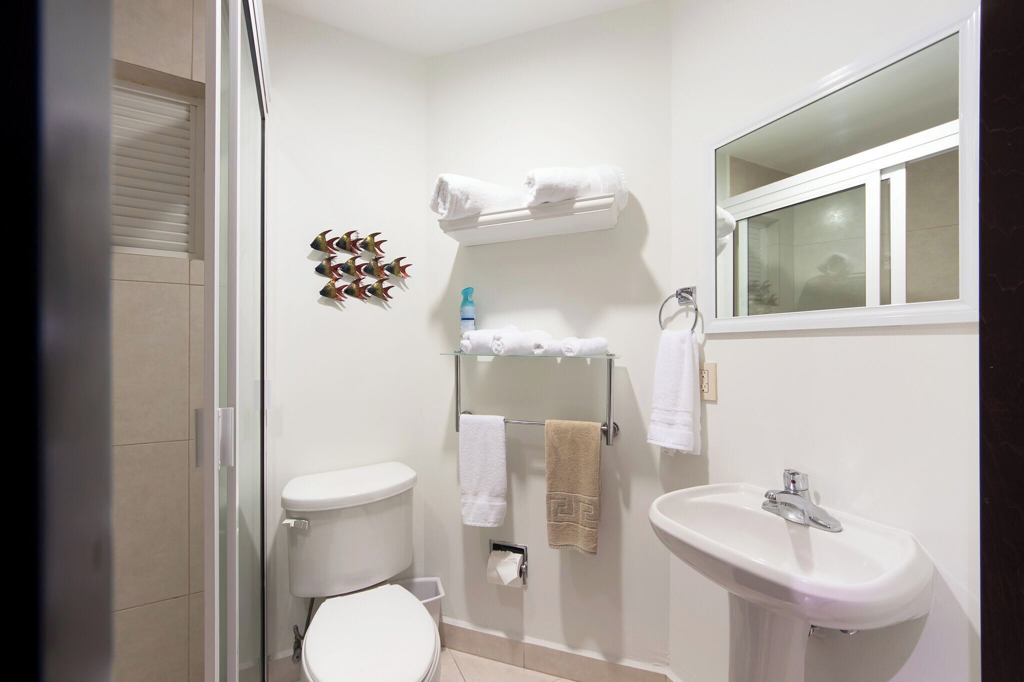 A bathroom with a toilet, sink, and shower.
