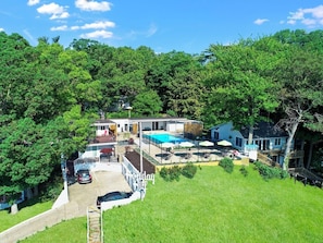 Una casa grande con piscina, patio cubierto y jardín cercado.