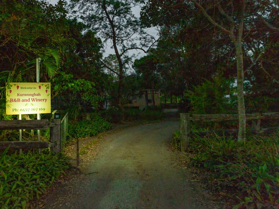 Señal de bienvenida a los visitantes del B&B y viñedo Kurwongbah, con un número de contacto.