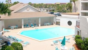 A hotel pool area with lounge chairs and umbrellas, surrounded by palm trees and a clear sky. - Dir Ocean Front 2 BR/2 BA Condo (ST AUGUSTINE)