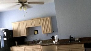 A kitchen with beige cabinets, a black refrigerator, a ceiling fan, and a trash can. - $120.00 por noche .Full house 2/2<br>$100.00 cleaning fee<br>$30.00 Pet fee, per stay (Uvalda)