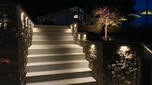 Una escalera con paredes de piedra e iluminación a lo largo de los peldaños.
