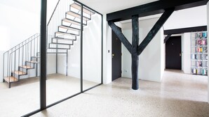 Ein modernes Interieur mit einer Treppe, einer Glaswand und einem Bücherregal.
