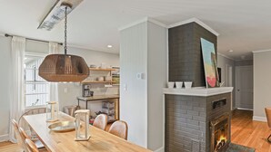 Un comedor con una mesa de madera, sillas y una lámpara colgante.