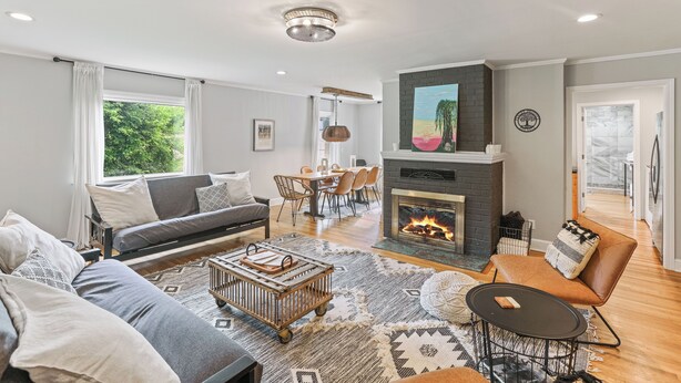 Una sala de estar moderna con chimenea, un sofá, una mesa de centro y un comedor.