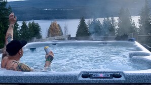 Un jacuzzi con vistas a un lago y montañas.