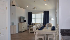A dining area with a wooden table, chairs, and a ceiling fan. - Rehoboth Beach Condo Elevator Pool Parking Clean (Rehoboth Beach)