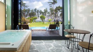 A spa area with a hot tub, two lounge chairs, and a table with chairs. - Pool Villa Linderburg (Taean)