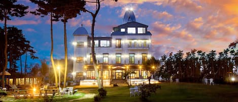 Vista frontal de la propiedad por la tarde o noche