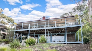 A two-story building with a flat roof and a balcony on the upper floor.