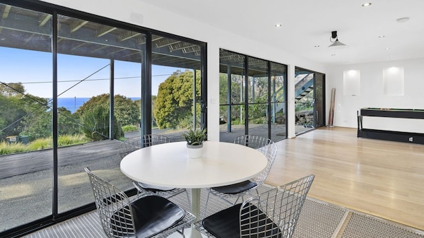 A modern room with a round table, chairs, and a pool table.