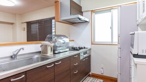Une cuisine moderne équipée d’un évier en acier inoxydable, d’une cuisinière à gaz, d’un four encastré et d’un four à micro-ondes.