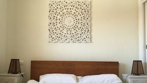 A neatly made bed with white linens, a wooden headboard, and two bedside tables with lamps. - SENSES BUILDING HAPPINESS APARTMENT (Tarifa)