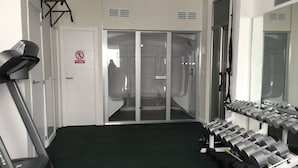 A gym with a treadmill, weight bench, and dumbbells. - SENSES BUILDING HAPPINESS APARTMENT (Tarifa)