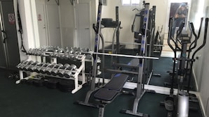 A gym with weightlifting equipment, dumbbells, and exercise machines. - SENSES BUILDING HAPPINESS APARTMENT (Tarifa)