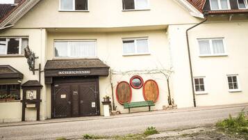 A building with a sign reading "KÜFERSCHANKE" and a bench in front.
