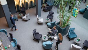 Amplio espacio interior con varios conjuntos de asientos, incluyendo sofás y sillones, dispuestos alrededor de mesas.
