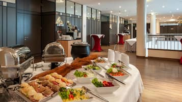 Disposición de bufé con diversos alimentos y una estación de café en un hotel moderno.