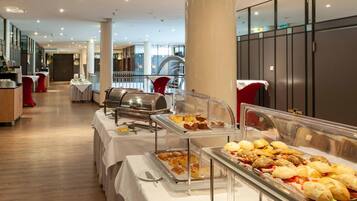 A buffet area with various food options, including pastries and sandwiches, in a hotel setting.