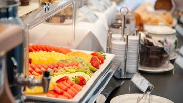 A buffet with a variety of fruits and pastries.