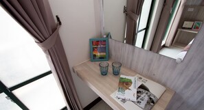 A room with a wooden table, two blue glasses, a framed picture, and a poster. - Jia-Jia Business Hotel (Luodong)