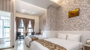 Ein Hotelzimmer mit zwei Betten, einem Schreibtisch und einem Stuhl.