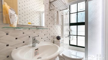 Ein modernes Badezimmer mit einem großen weißen Waschbecken, einer Glasablage, einem Handtuchhalter und einem Fenster mit Ausblick.
