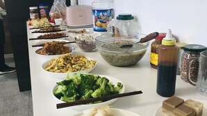 Ein reichhaltiges Buffet mit verschiedenen Speisen, darunter Brokkoli, eine Suppenschüssel und mehrere Beilagen.