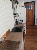Una cocina con encimera de madera, estufa integrada y refrigerador.
