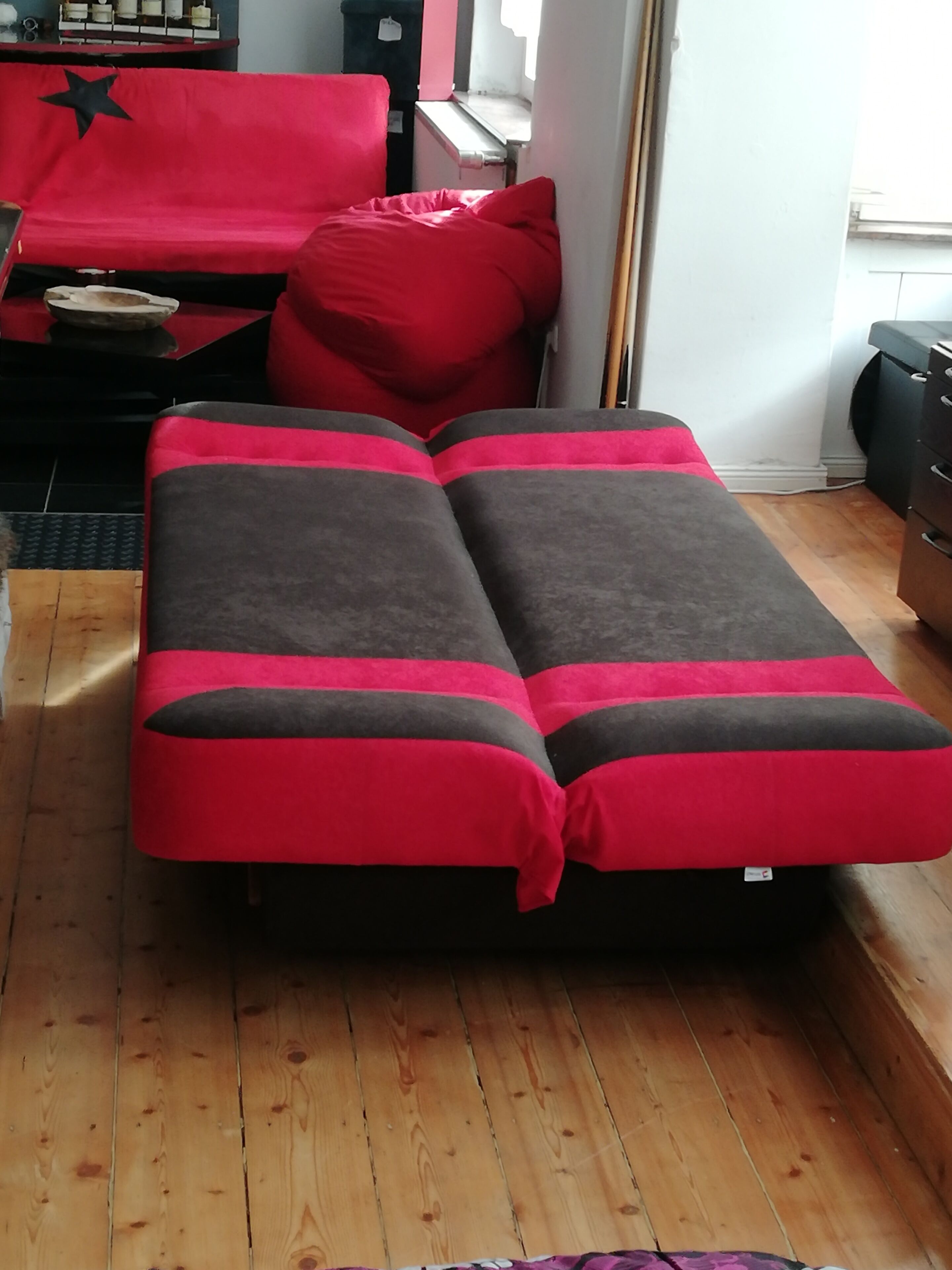 A room with a bed, a small table, and a window.