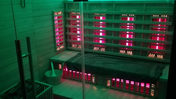 A room with a sloped ceiling, wooden walls, and a series of illuminated cabinets. - Privatzimmer Hagen (Hagen)
