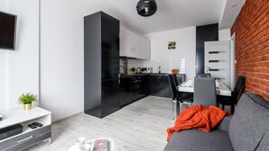 A modern apartment with a kitchen, dining area, and living room. - Chmielna Premium z dwoma sypialniami (Warsaw)