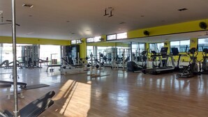 A gym with various exercise equipment, large windows, and a wooden floor. - Yellow Durbar Apartment and Lounge (Lalitpur)