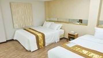 A hotel room with two beds, a bedside table, and a large window.