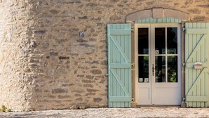 Un edificio de piedra con puerta de recepción, un cartel que indica que es un hotel y un buzón.