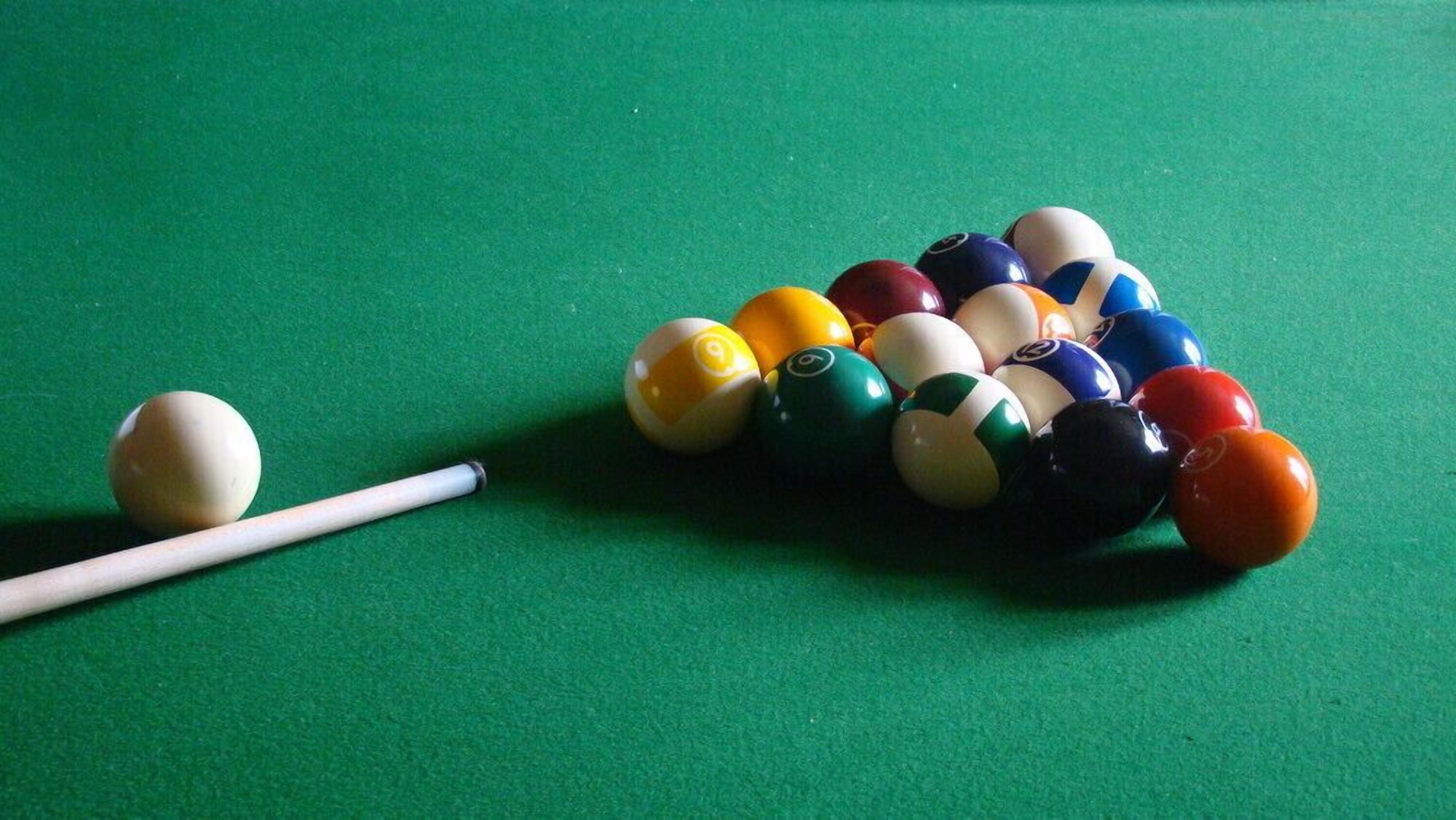 Une table de billard avec des billes de différentes couleurs et un queue de billard.