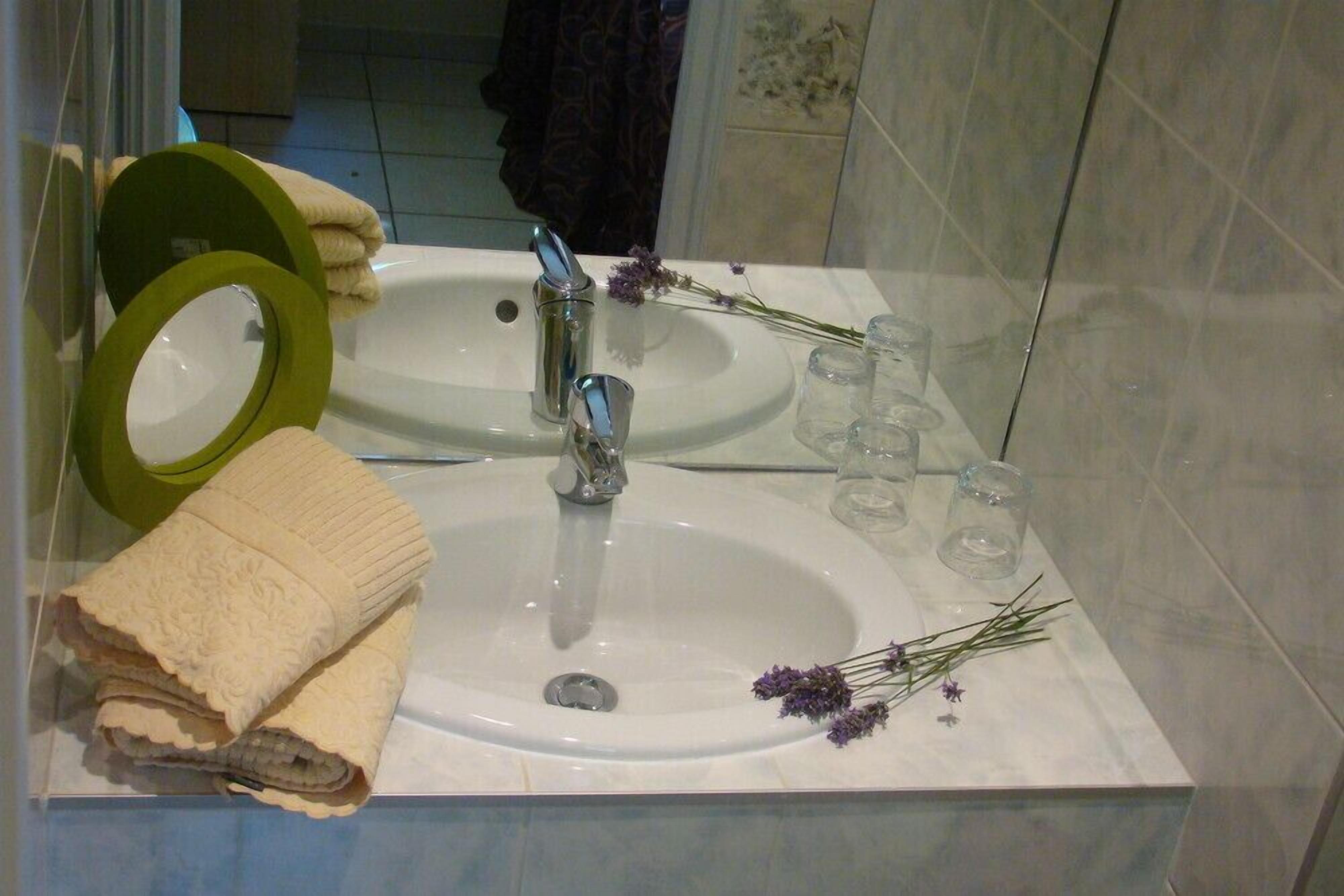 Une salle de bain avec deux lavabos, un porte-serviettes vert et un miroir.