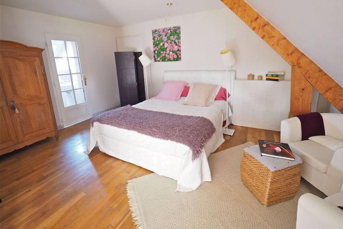 Een slaapkamer met een bed, een kledingkast, een bureau en een stoel.
