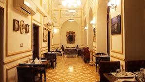 Un hall d’hôtel doté d’un sol à motifs, de décorations murales élaborées et d’un espace salon central.